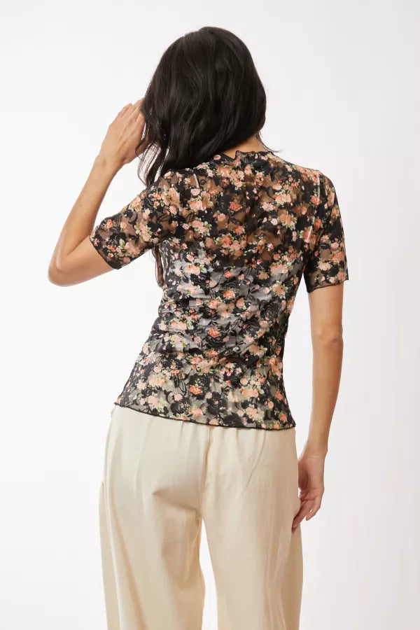 woman modeling a floral mesh top