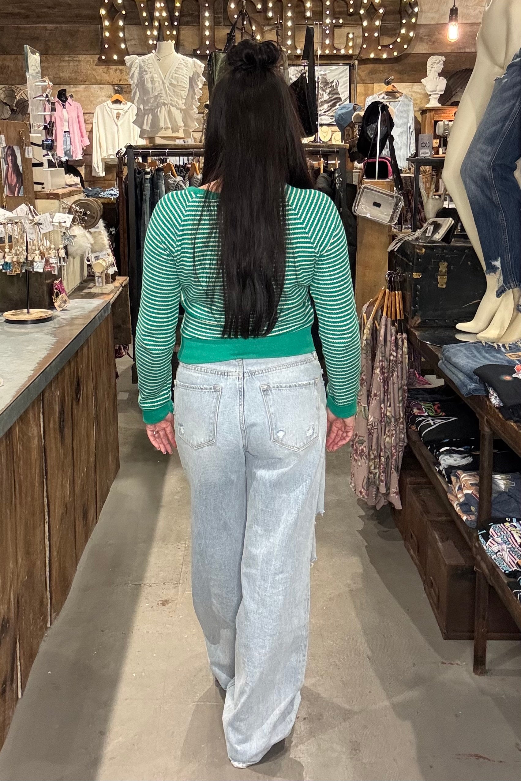 Model showing the back of a green and white cropped long sleeve top