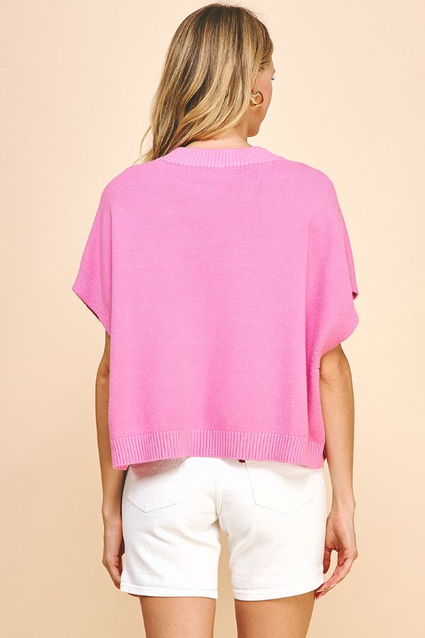 Model in pink top and white skinny jeans - back view