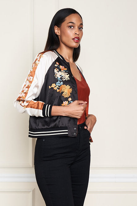 Woman wearing a black and white satin embroidered reversable jacket