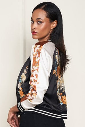 Woman wearing a black and white satin embroidered reversable jacket