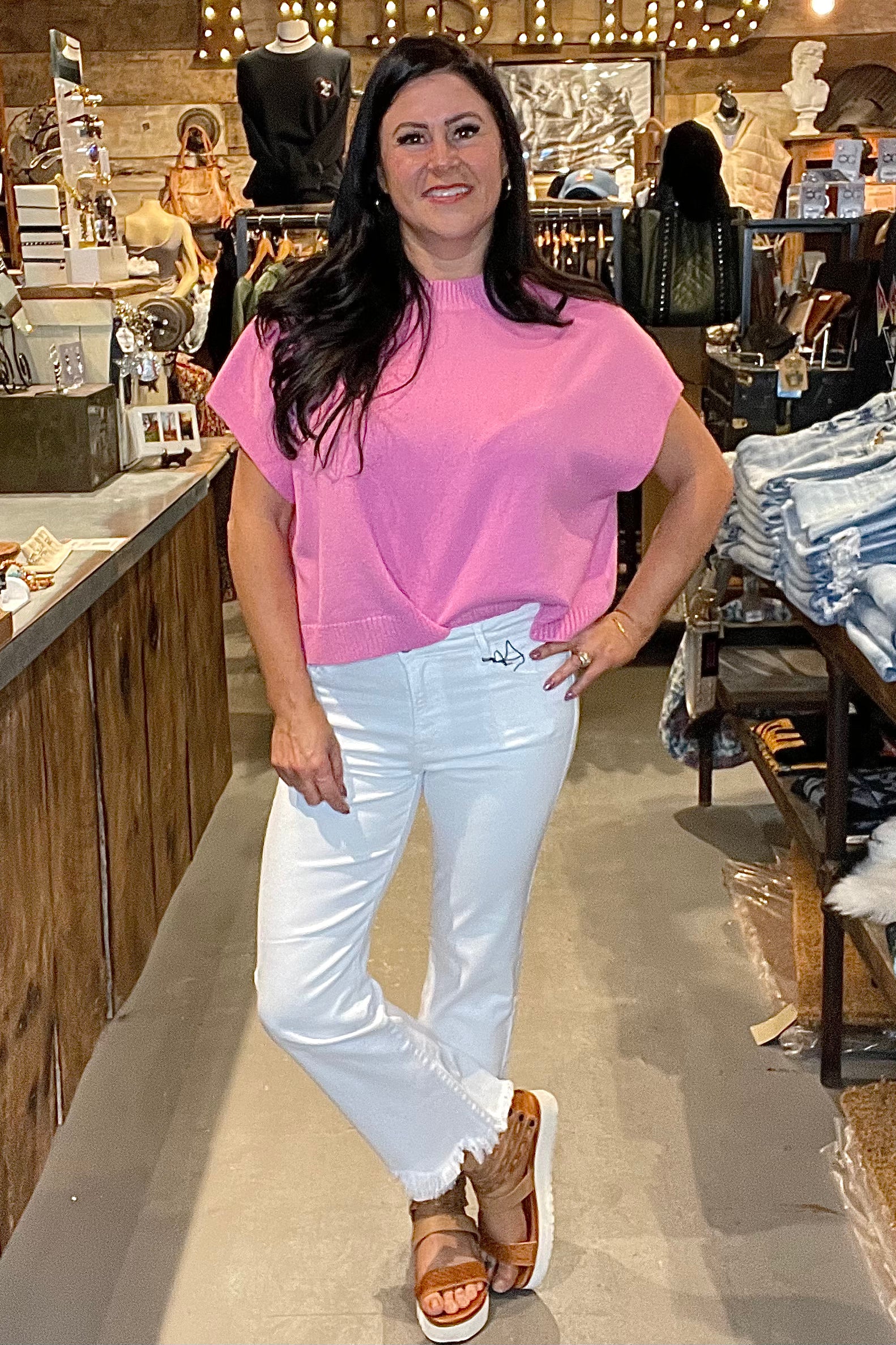 Model in pink top and white skinny jeans