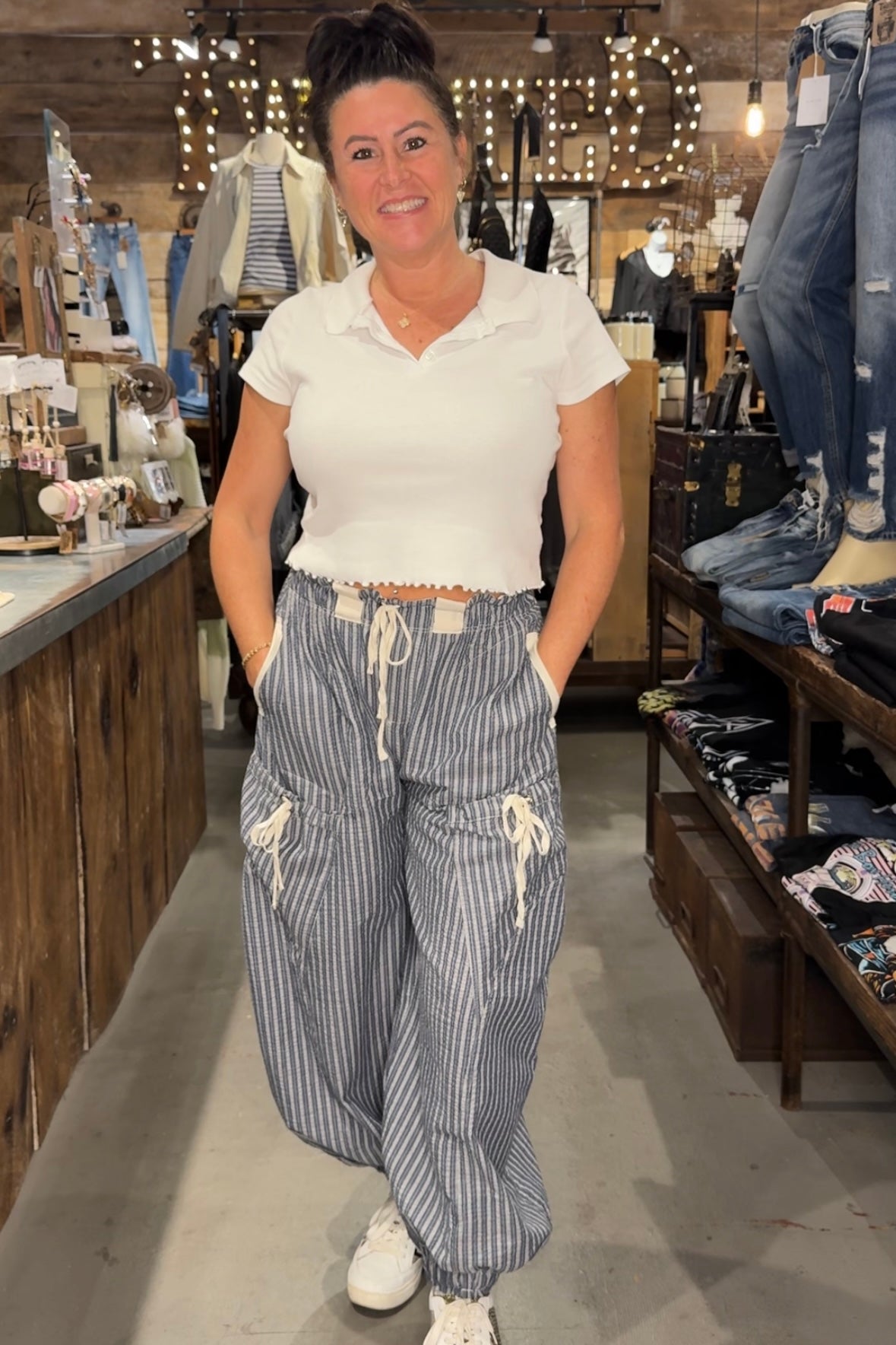 Woman wearing white shirt and navy blue striped jogger pants with drawstrings