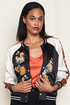 Woman wearing a black and white satin embroidered reversable jacket