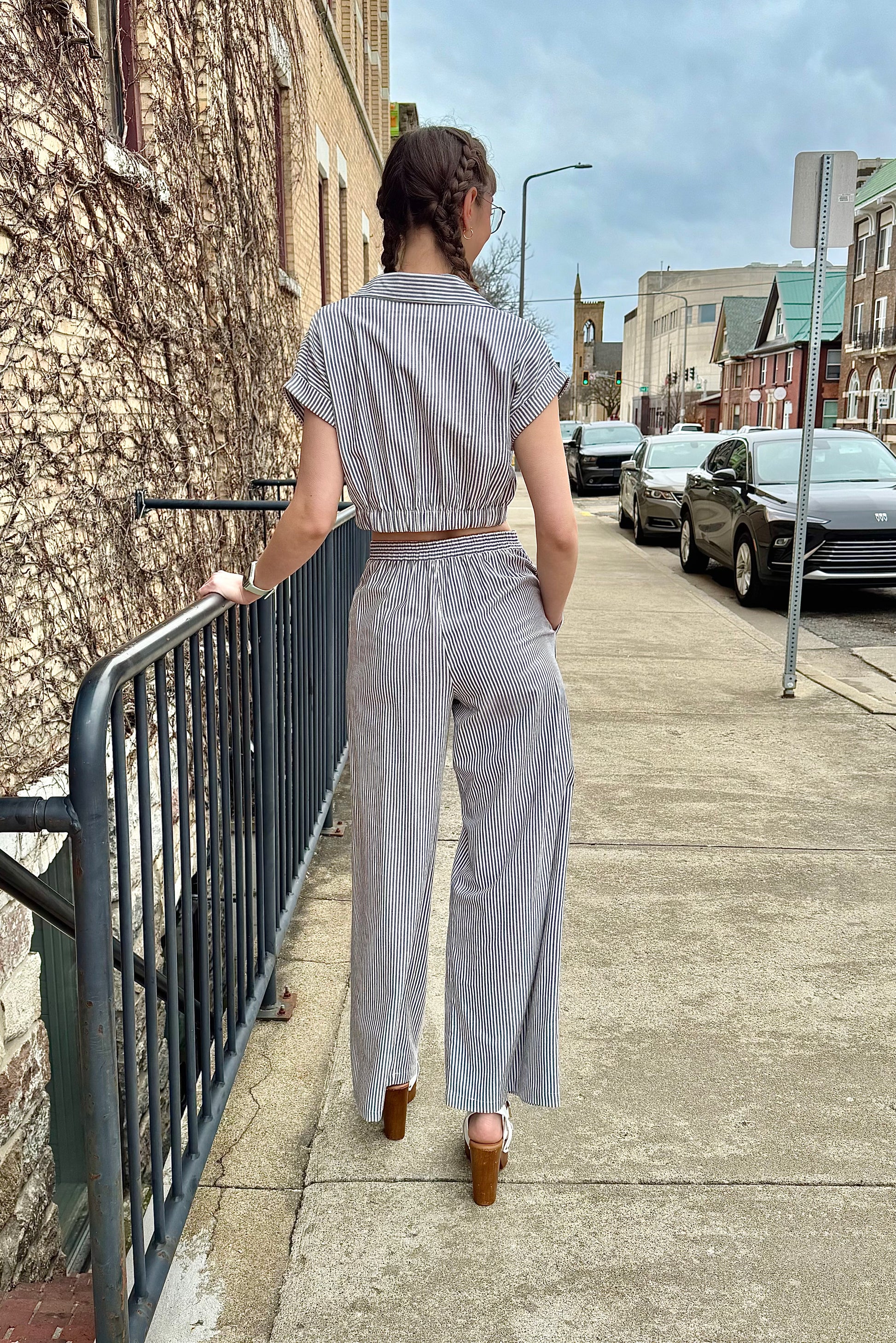 A person viewed from behind wearing striped high waist wide leg pants with a matching top.
