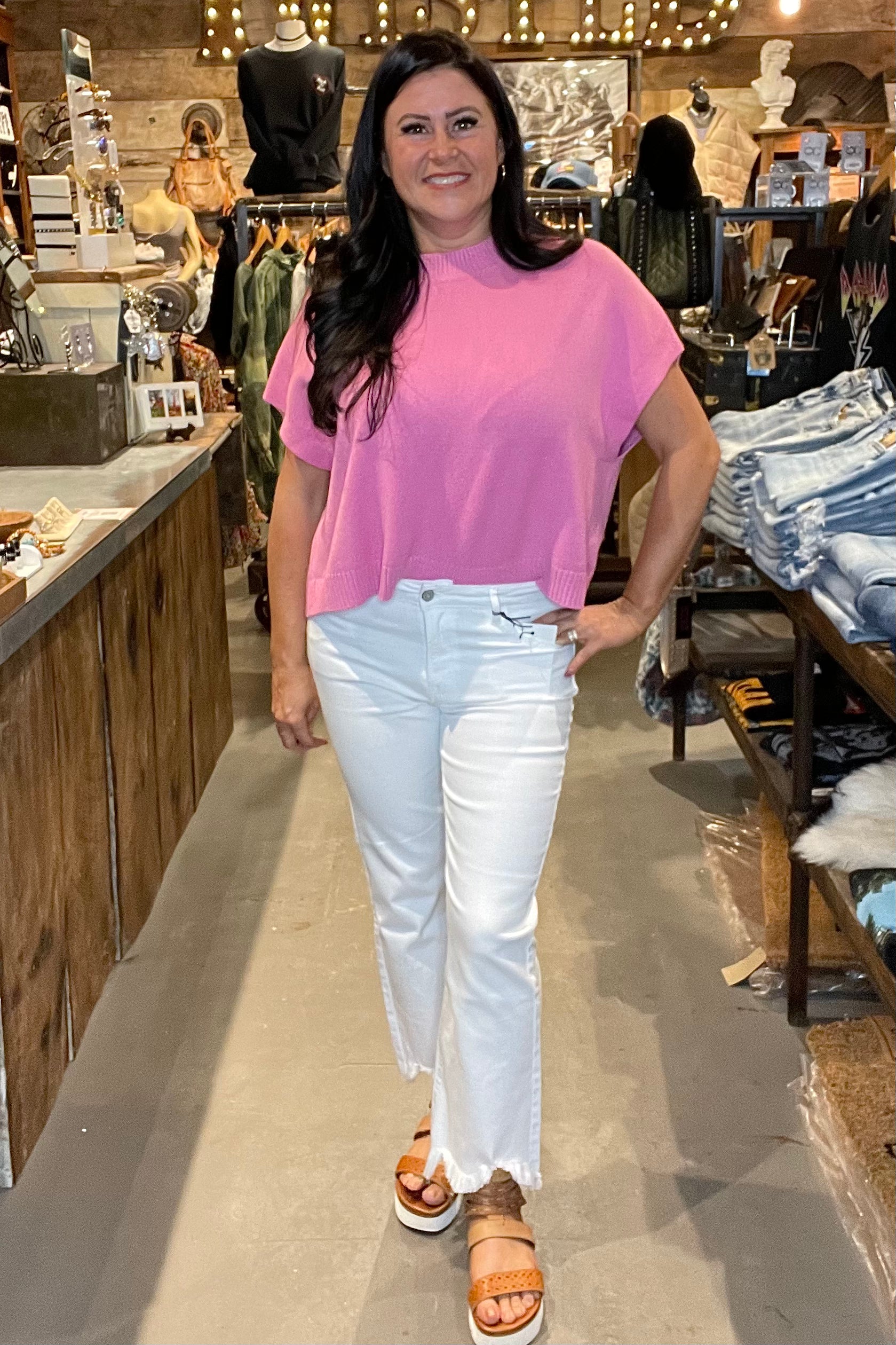 Model in pink top and white skinny jeans